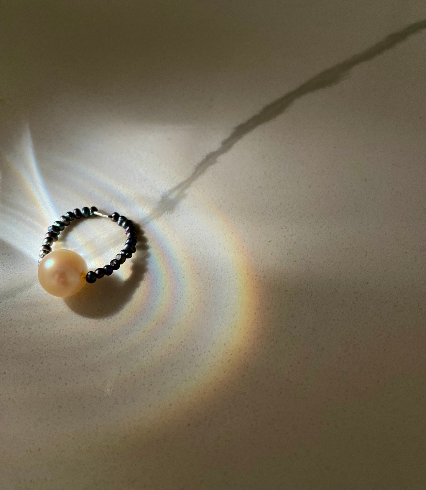 The Ocean Halo ring on peacock pearls